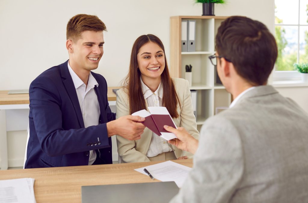 Happy,Couple,Meeting,With,Visa,Manager,Or,Travel,Agency,Worker.